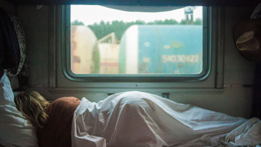 femme dort sur un lit qui donne sur une fenêtre